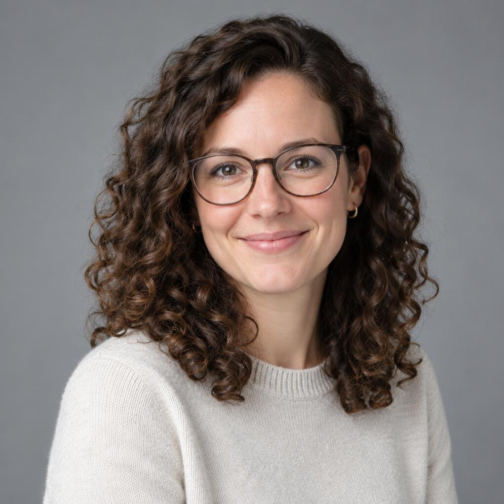 Studio portrait of a young Swiss woman data analyst with curly hair and glasses