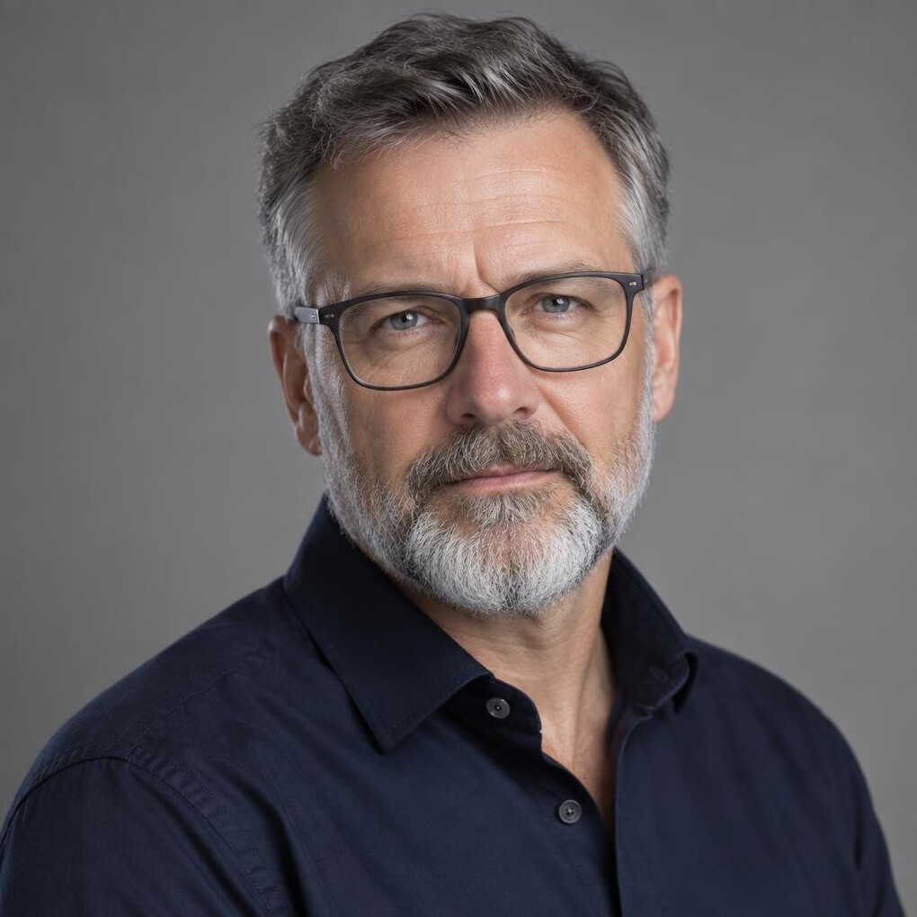 Studio portrait of a Swiss man investigative journalist in his fifties with grey beard and glasses
